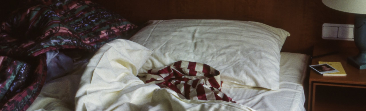 Huckepack (Piggyback) - unmade hotel room bed