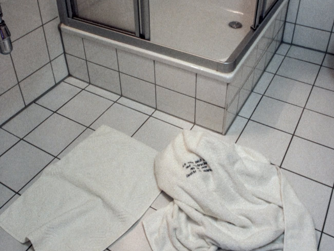 Side Effects, embroydered message on towel on floor
